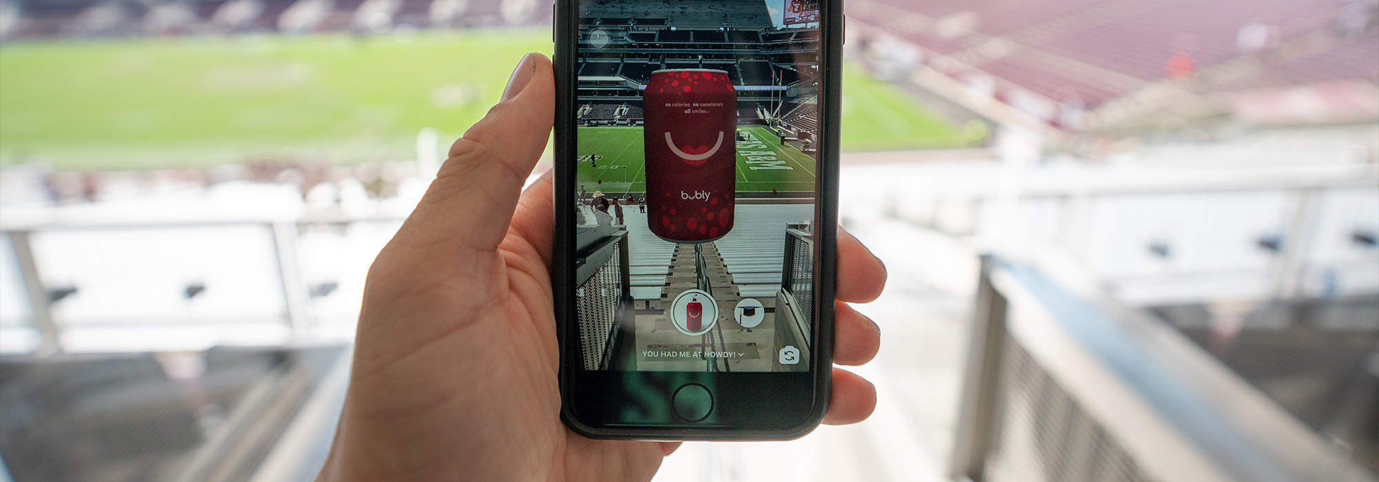 Hand holding up VR Bubly Howdy Tab filter inside Kyle Field