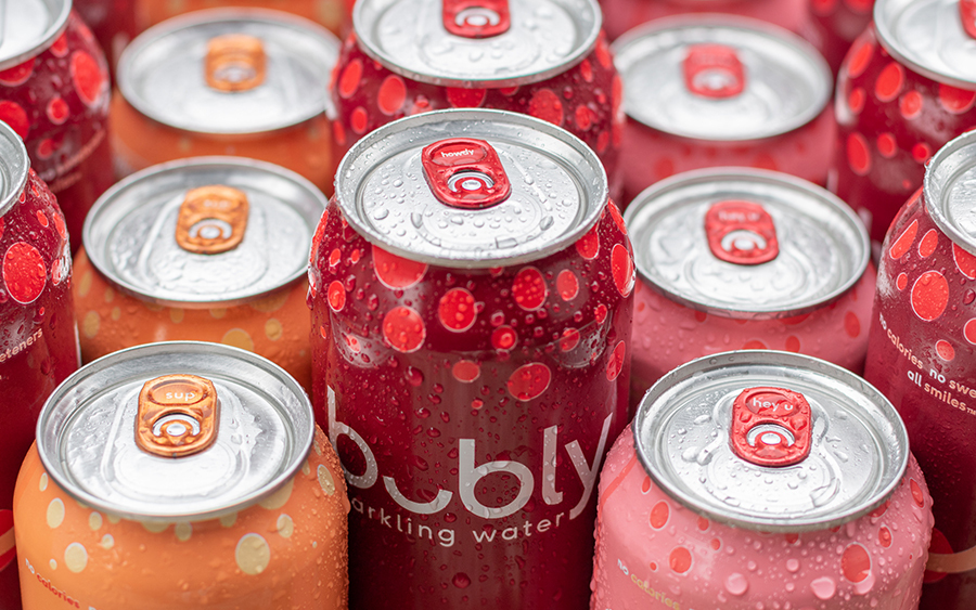 Colorful Bubly sparkling water cans lined up with the middle line showcasing Bubly Howdy tab cans