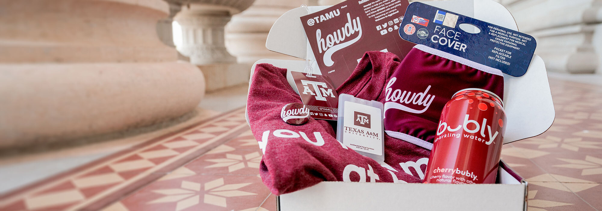 TAMU Howdy week prize box including a t-shirt, hand sanitizer, stickers, and co branded bubly