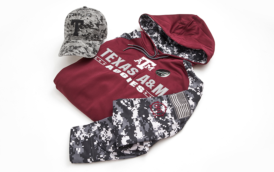 TAMU and Operation Hat Trick branded merchandise laid out on a white background. Items include a camo hat and maroon and camo sweatshirt. 