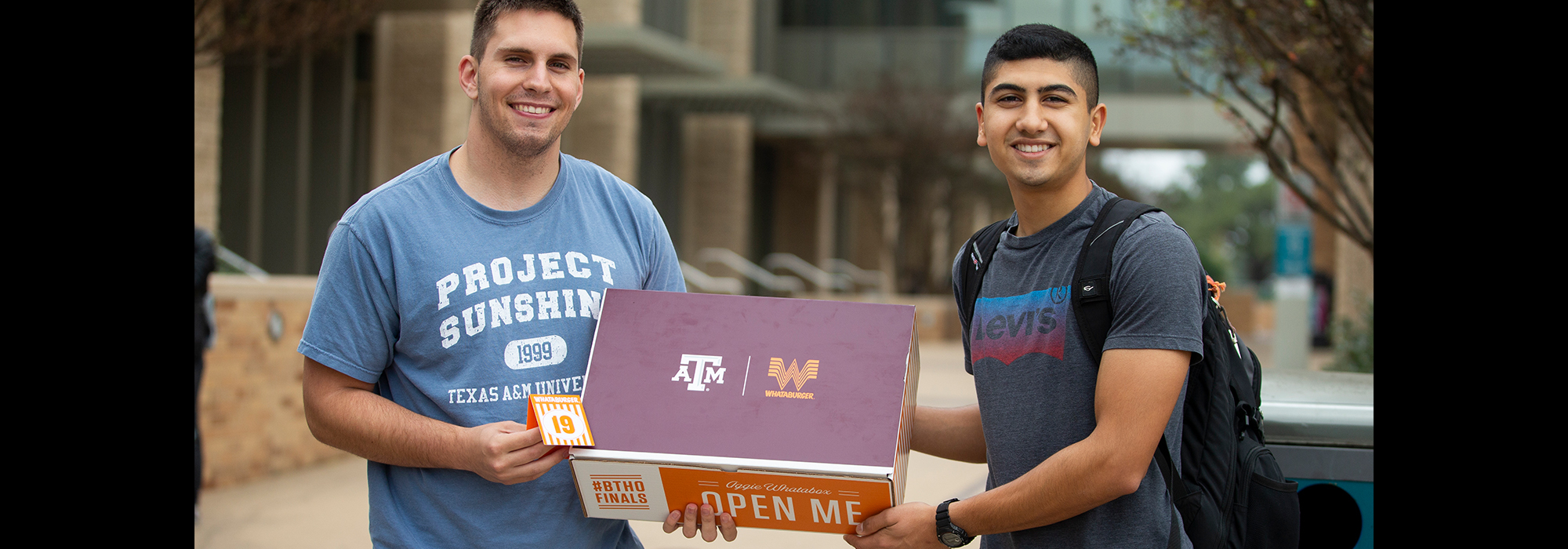 Two TAMU students holding a Whataboxe