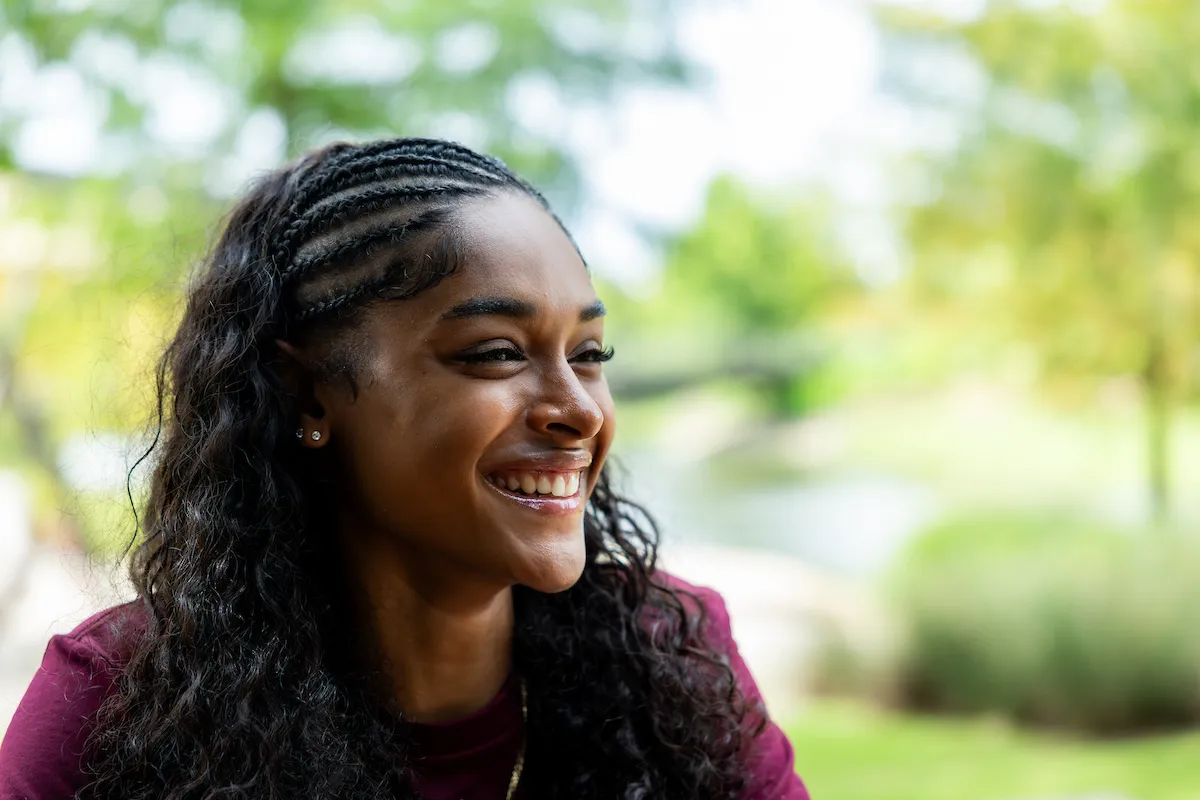Portrait of an Aggie student outdoors with lighting that draws out highlights and shadows on her face